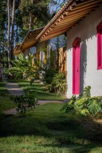 uma casa com uma porta rosa e um quintal em Villa Mediterrâneo Trancoso em Trancoso