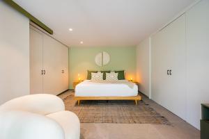 1 Schlafzimmer mit einem Bett und 2 Stühlen in der Unterkunft Capitalia - Luxury Apartments - Polanco - Alejandro Dumas in Mexiko-Stadt
