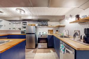a kitchen with blue cabinets and a stainless steel refrigerator at Multnomah Village Hideaway in Portland