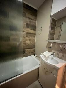 y baño con bañera, lavamanos y ducha. en Select Inn en Río Grande