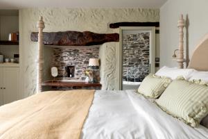 a bedroom with a large white bed with a stone wall at The Penn in Windermere