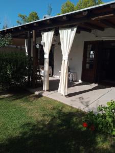 un pabellón con cortinas blancas en un patio en SANTA FE HOUSE en Ciudad Lujan de Cuyo