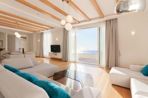 una sala de estar con muebles blancos y vistas al océano. en Villa Hedonism, en Sveti Stefan