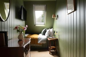 a green bedroom with a bed and a window at The Penn in Windermere