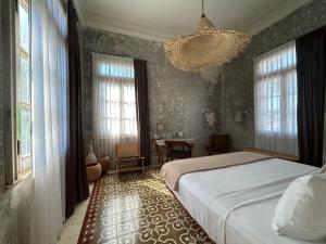 a bedroom with a bed and a chandelier at Historic House Hotel boutique in Mérida