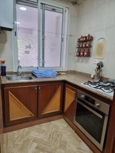 cocina con fregadero, fogones y ventana en Authentic moroccan apartment, en Rabat
