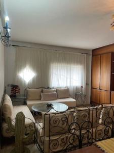 sala de estar con sofá y mesa en Authentic moroccan apartment, en Rabat