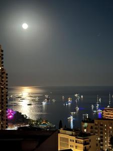 uma vista de uma cidade à noite com barcos na água em Vue Mer à Proximité de Monaco em Beausoleil