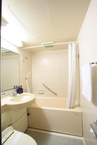 un bagno con vasca, lavandino e WC di Hotel Ermou Regency a Numazu