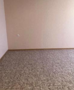 an empty room with a white wall and carpet at Apartment big home in La Ricamarie