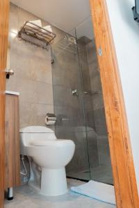 a bathroom with a toilet and a glass shower at Hotel Encanto in Manizales
