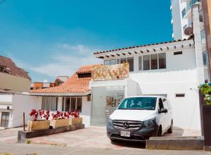 a white van parked in front of a building at Hotel Encanto in Manizales