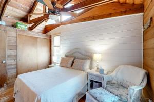 1 dormitorio con 1 cama y 1 silla en Tower Shores --- 39578 Admiral Road, en Bethany Beach