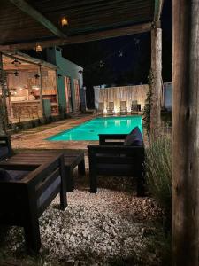 una piscina di notte con panchine e un tavolo di El Descanso! a Concordia