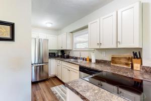 eine Küche mit weißen Schränken und einem Kühlschrank aus Edelstahl in der Unterkunft Riverside Serenity - Unit B in Bradenton