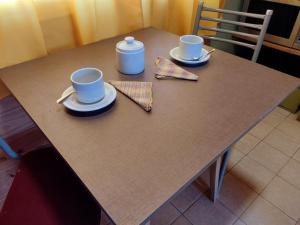 a table with two cups and saucers on it at La cabaña in San Antonio de Areco
