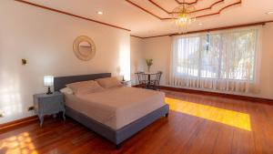 a bedroom with a bed and a large window at Casa Familiar la Tortuga in Heredia
