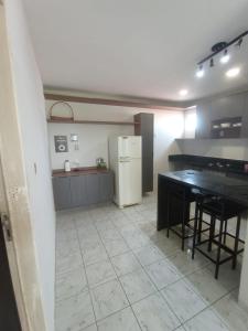 a kitchen with a table and a refrigerator at Minha casa fora de casa in João Pessoa