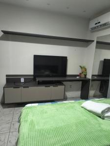- un salon avec une télévision et un lit dans l'établissement Minha casa fora de casa, à João Pessoa