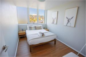 a small bedroom with a bed and two windows at Central Getaway, On Rundle St in Adelaide