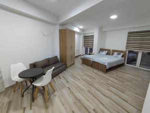 a bedroom with a bed and a table and a couch at Paradiso Apartments in Ohrid