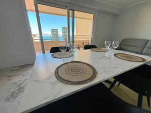 a dining table with wine glasses and a view of the ocean at Vue Mer à Proximité de Monaco in Beausoleil
