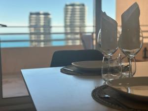 uma mesa com dois copos de vinho e pratos em Vue Mer à Proximité de Monaco em Beausoleil