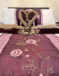 バーミンガムにある2 Rooms in Great Barr - Near M5/M6 - Parking - Gardenの紫色のベッドカバーと皿が付いたベッド