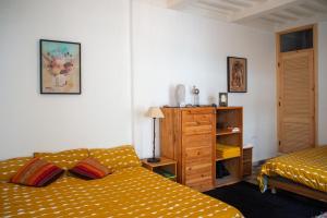 een slaapkamer met 2 bedden en een dressoir. bij DAR ORY in Essaouira
