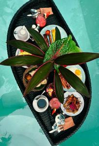 a table with plates of food and a plant on it at Exotic Private Glamping in Nusa Penida