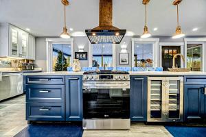 a large kitchen with blue cabinets and a stove at Luxury Spa Chalet in Greenwood