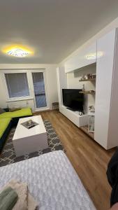 a living room with a bed and a table and a tv at Apartman City Park Stráňany in Michalovce