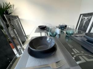 a table with a black bowl and plates and wine glasses at Wigan Haven Modern & Relaxing in Pemberton