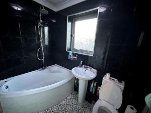 a bathroom with a tub and a sink and a toilet at Wigan Haven Modern & Relaxing in Pemberton