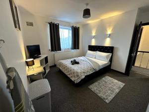 a bedroom with a bed and a television in it at Wigan Haven Modern & Relaxing in Pemberton