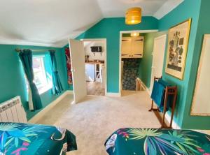 ein Wohnzimmer mit grünen Wänden und ein Schlafzimmer in der Unterkunft Traveller's Rest - Cosy cottage in heart of Wilton in Salisbury