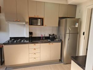 a kitchen with a refrigerator and a sink at Studio Liberdade in São Paulo