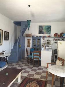 a living room with a kitchen and a dining room at School House with Panoramic View in Serifos Chora