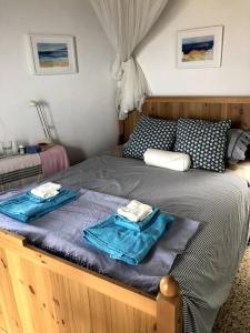 a bedroom with a bed with two towels on it at School House with Panoramic View in Serifos Chora