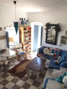 a living room with a blue couch and a table at School House with Panoramic View in Serifos Chora