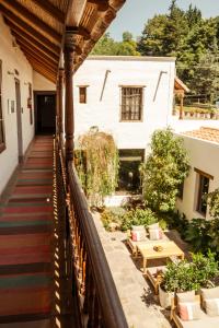 un balcone di una casa con tavolo e sedie di El Cortijo Hotel Boutique a Cachí