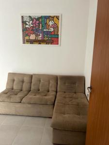 un sofá marrón en una habitación con una pintura en la pared en Ap piscina Franca florenza en Franca