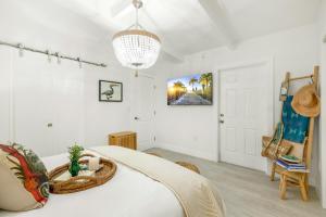 a bedroom with a bed and a chandelier at Carpe Diem - Seas The Day in Key Colony Beach