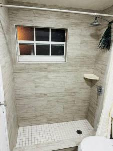 uma casa de banho com um chuveiro, um WC e uma janela. em Miami Studio near Airport/Beach em Miami