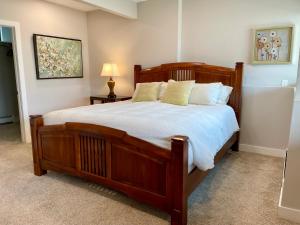 een slaapkamer met een groot houten bed met witte lakens bij Cozy Retreat 100% remodeled in Arvada