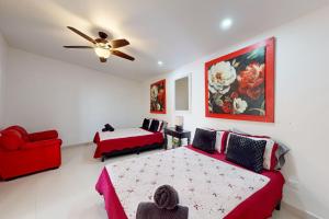 a bedroom with two beds and a ceiling fan at Villa Ambar 55 - Playa Arcangel in Rosarito