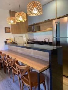 a kitchen with a counter with chairs around it at Village 115 Barra Grande (Viva Barra) in Marau