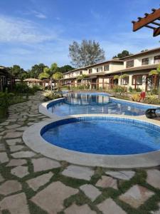 a swimming pool in a courtyard with a building at Village 115 Barra Grande (Viva Barra) in Marau