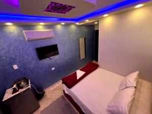 a bedroom with a bed and a tv in a room at Orion pyramids view in Cairo