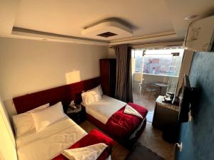 um quarto de hotel com duas camas e uma televisão em Orion pyramids view no Cairo